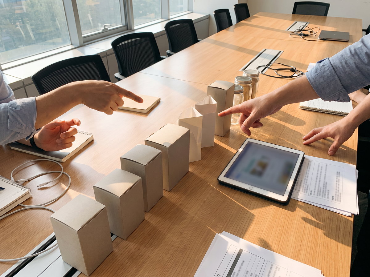 cosmetic packaging sourcing brief being reviewed at a meeting table