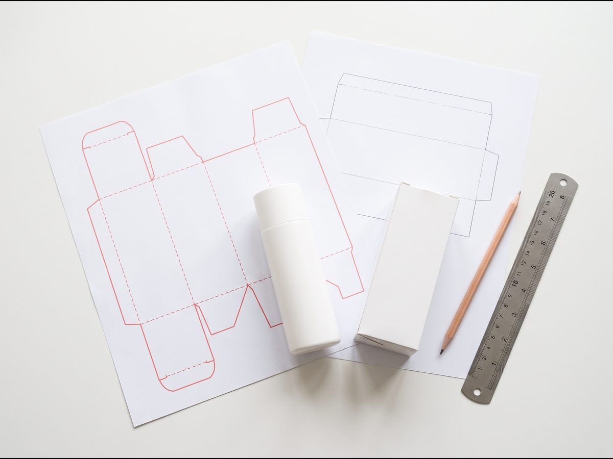 printed carton and label dielines with cut and fold lines beside blank cosmetic packaging